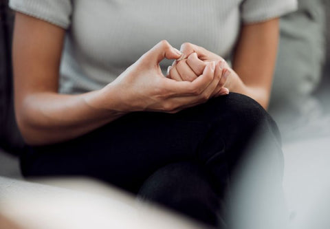 femme qui se tient les mains car elle est stressée