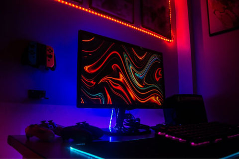 ordinateur gaming posé sur un bureau avec rétroéclairage rouge et bleu