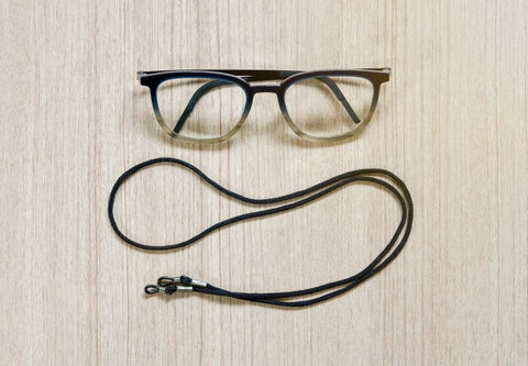 lunettes avec chaine sur fond bois