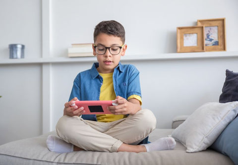 un enfant joue sur son lit à une console nintendo switch