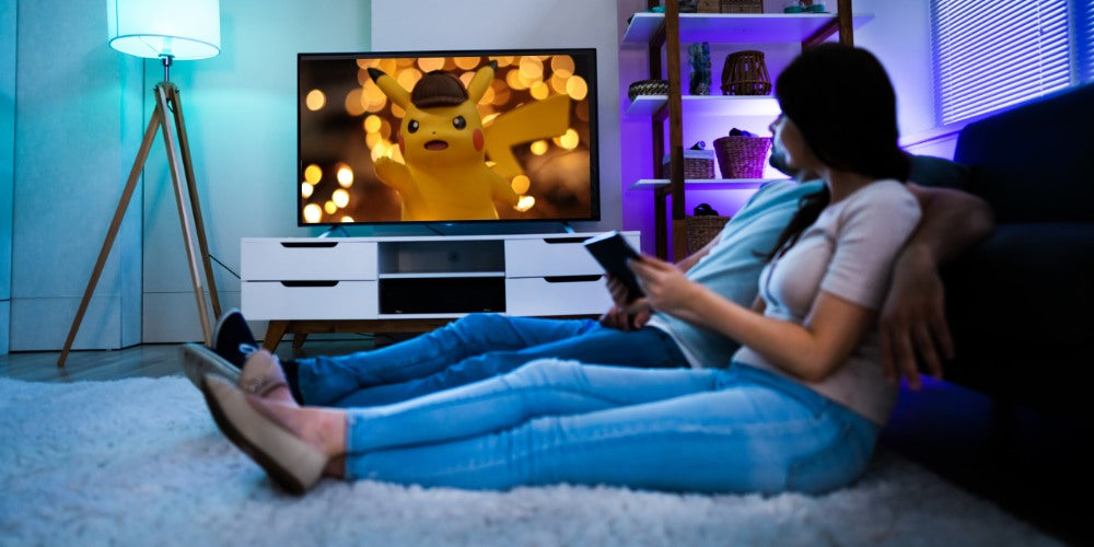 deux personnes regardent Pokémon à la télé