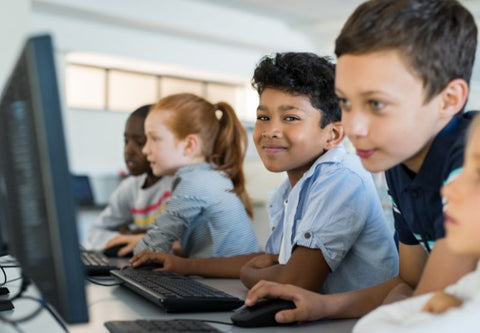 quatre enfants au CDI en train de regarder des écrans