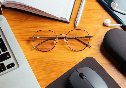 Lunettes anti lumière bleue Ushuaia de horus X sur un bureau entouré d'autres accessoires de bureau