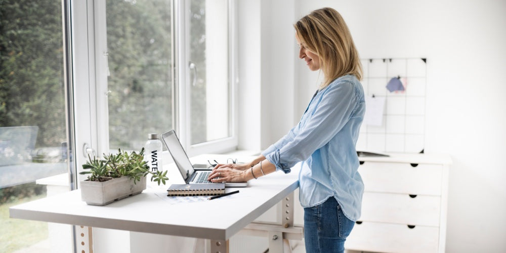 femme travaillant à un poste de travail debout ergonomique