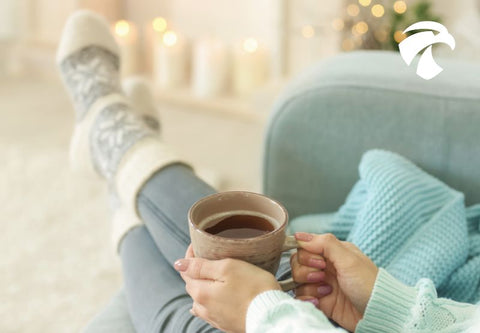 Frau mit einer Tasse Kaffee, die auf ihrem Sofa ruht