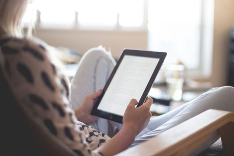 Woman reading her kindle paperwhite e-reader