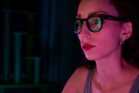 jeune femme exposée à la lumière bleue devant un écran