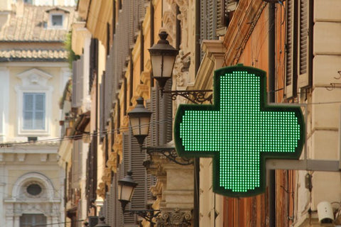 Grünes Kreuz-Apothekenschild in einer französischen Straße