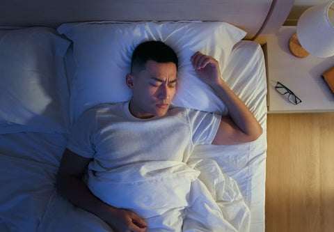 Mann im Bett unglücklich, weil zu viel Licht zum Einschlafen ist