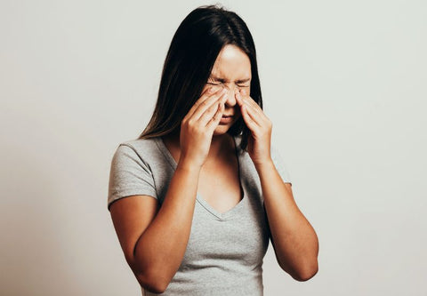 Jeune femme qui se frotte les yeux irrités