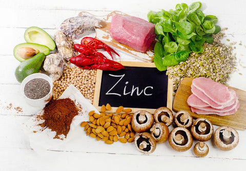 Une ardoise avec le mot zinc entourée d'aliments riches en zinc