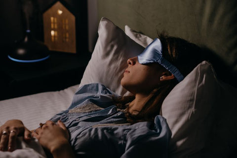 woman fell asleep comfortably in her bed with a sleep mask