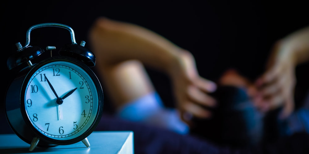 un homme au lit souffrant d'insomnie et de troubles du sommeil pensant à son problème la nuit