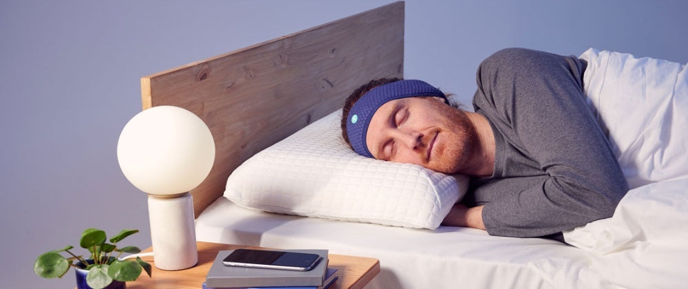 un homme portant un bandeau Hoomband, dormant sur le lit