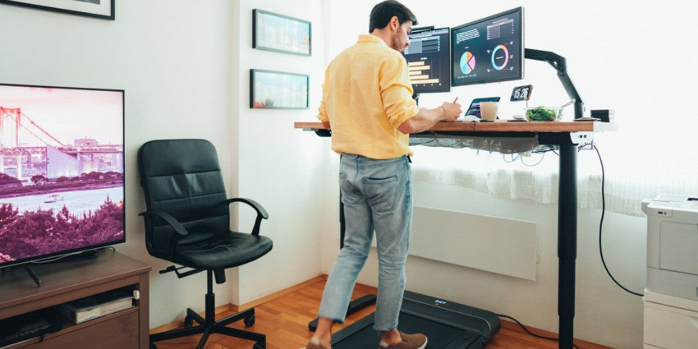 un homme sur un bureau assis debout avec des ordinateurs