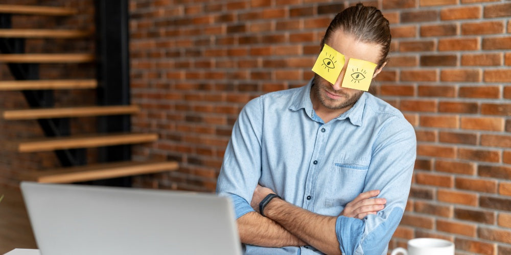 un jeune employé de bureau barbu faisant la sieste au travail