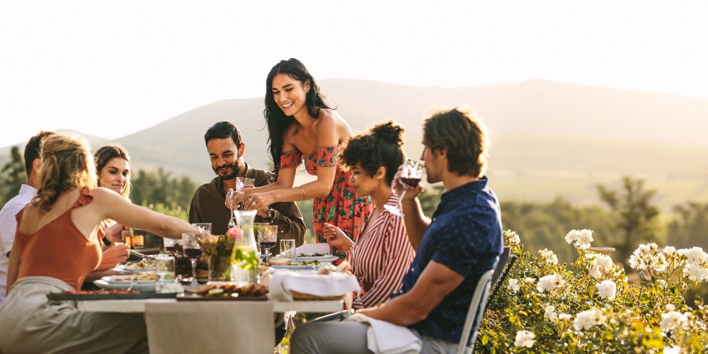 une Femme servant de la nourriture à des amis lors d'un dîner