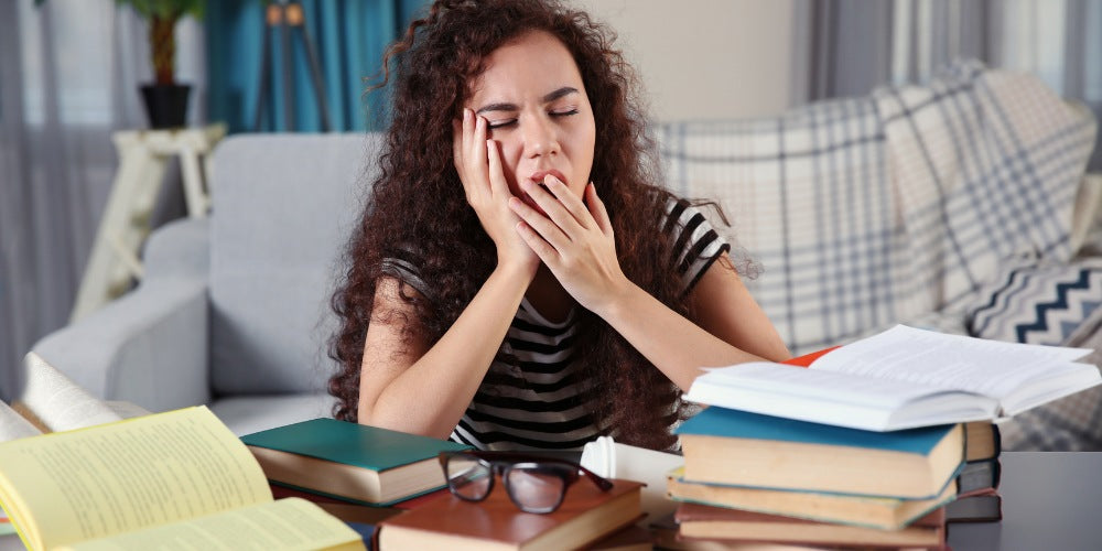 a student yawning while studying