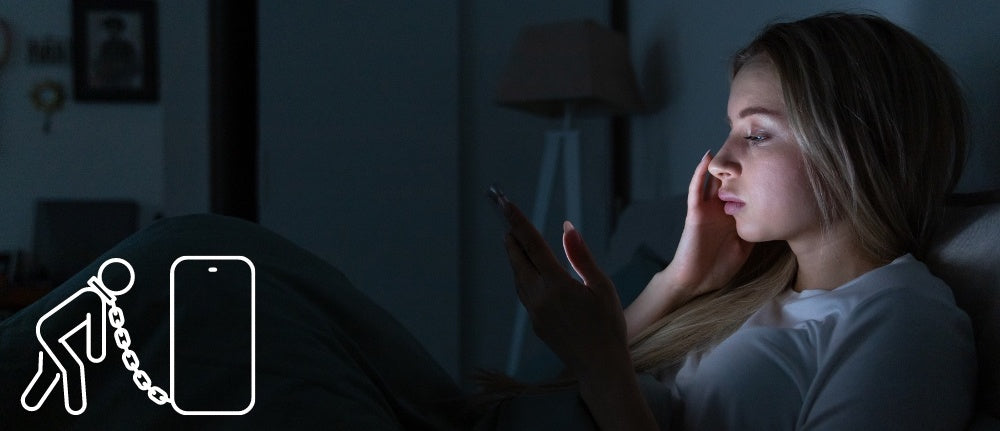 une femme allongée dans son lit et utilisant le téléphone la nuit