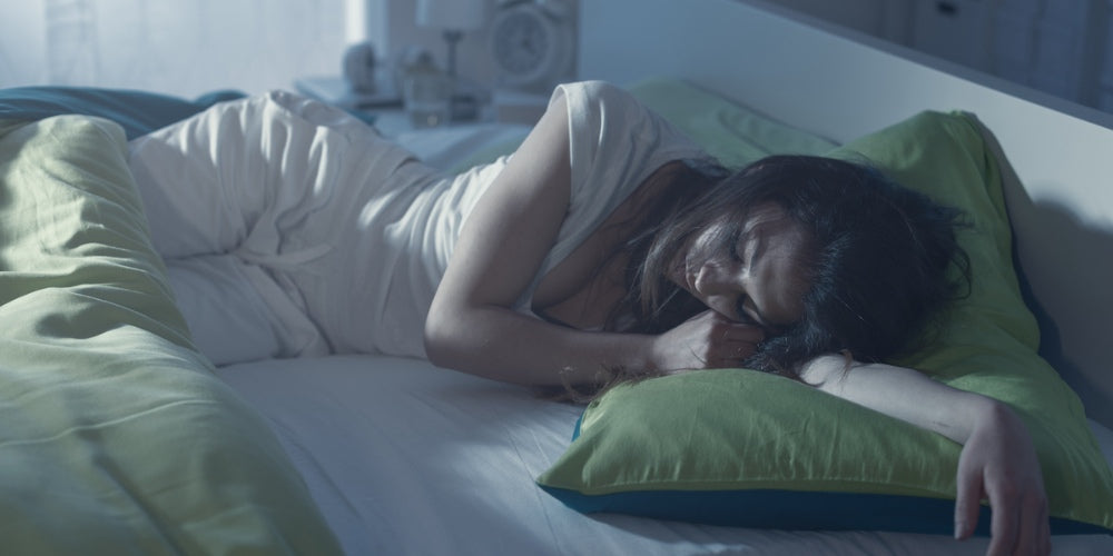 une femme dormant seule dans son lit pendant une chaude nuit d'été