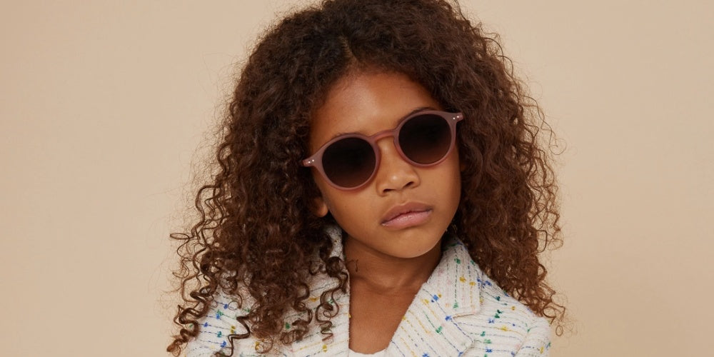 une petite fille portant des lunettes de soleil pour bébé Izipizi