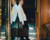 Man leans against window holding black briefcase