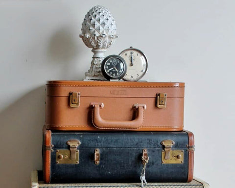 Rigid, rectangular vintage suitcases stacked on top of one another 