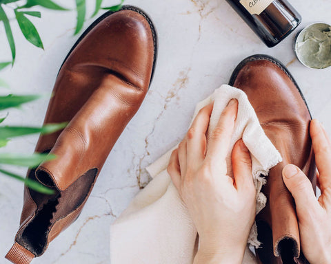 Waxing brown leather boots with a microfibre cloth