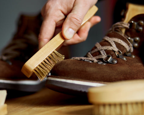 Cleaning brown suede shoes with a suede brush