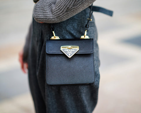 Female model wearing a black Saffiano leather Prada bag