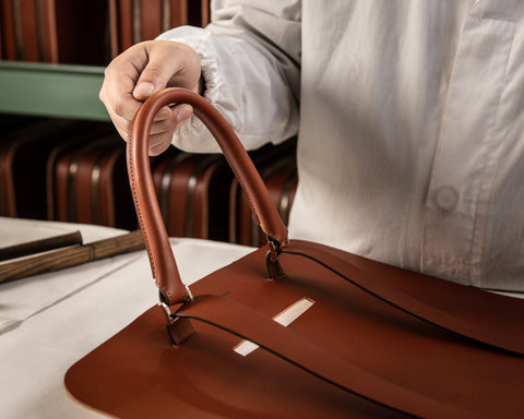 Leather worker manufacturing an Italian Saffiano leather briefcase