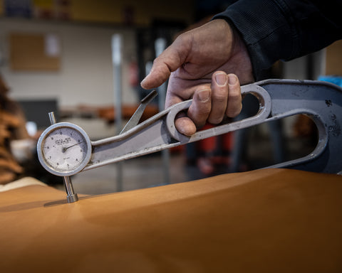 Tanner testing the thickness of leather in a tannery