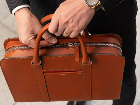 Zoomed in image of man holding Carl Friedrik Palissy Briefcase