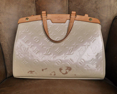 Discolouration of designer patent leather handbag