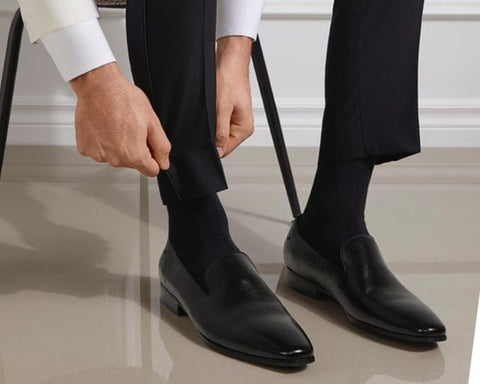 Man tying up black patent leather dress shoes