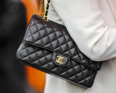 Black pebbbled leather Chanel bag draped over shoulder