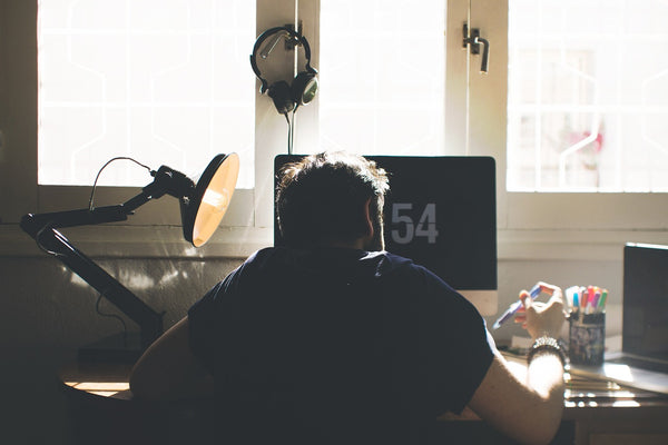 Homme entrain de travailler avec une très mauvaise posture liée a une mauvaise chaise de bureau qui entrainera des douleurs