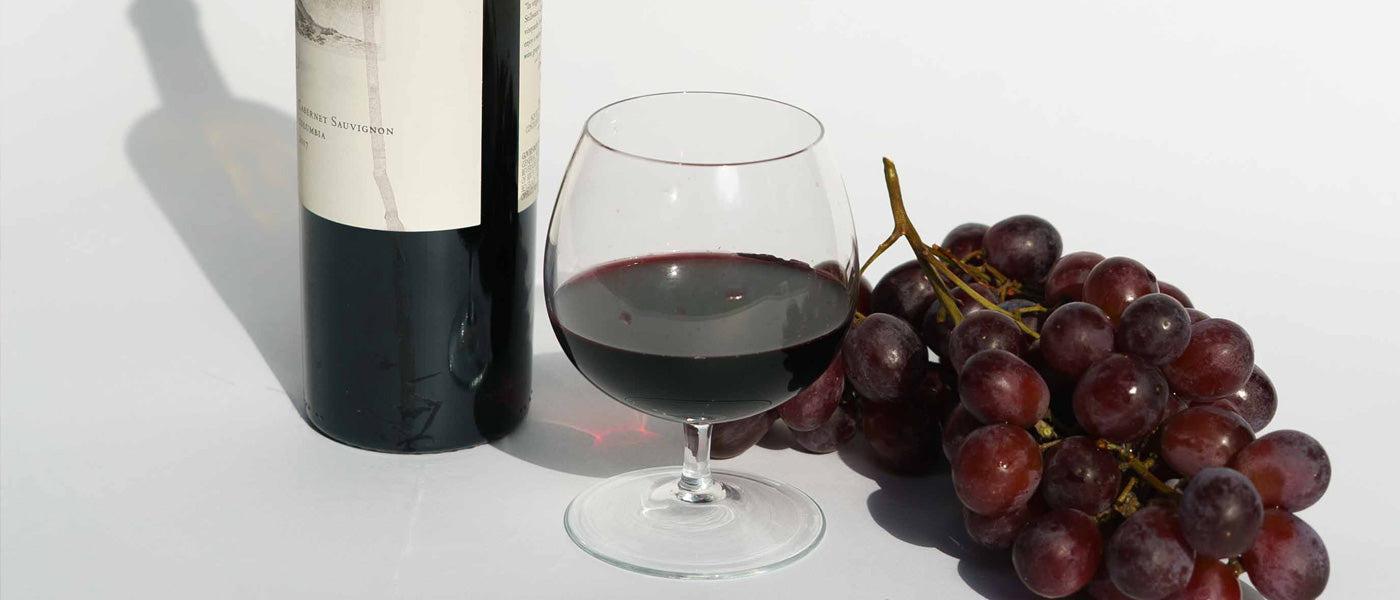 cabernet sauvignon in bowl glass with grapes