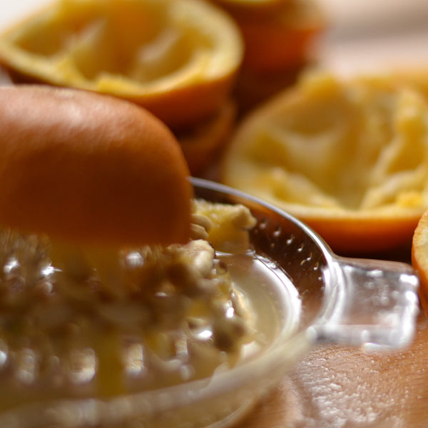 Quartered oranges, being squeezed