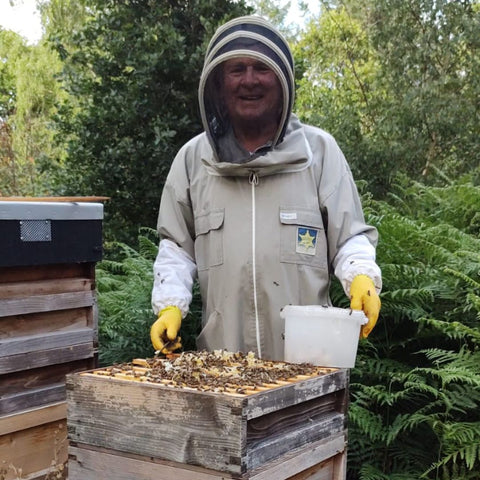 Roger Round bee keeper in the woods with his bee hives