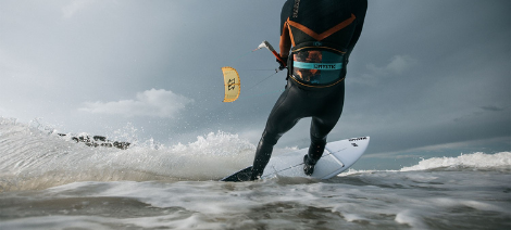 Male kitesurfer wearing harness in choppy water