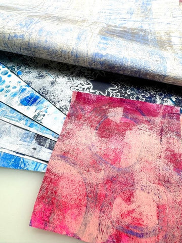 sheet of red gel printed washi paper on top of a stack of blue gel printed washi papers