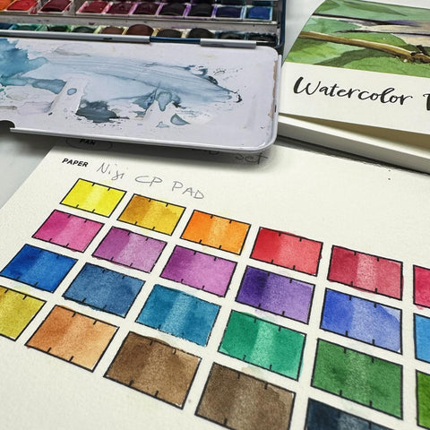 watercolor swatches with a watercolor palette and paper pad in the background