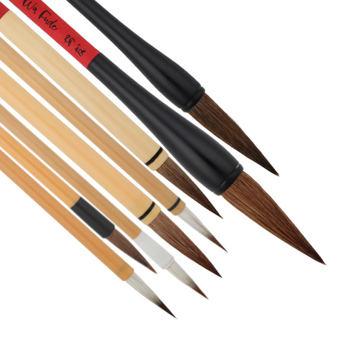 eight Wa Fude brushes pictured side by side pointing to the bottom right of the picture