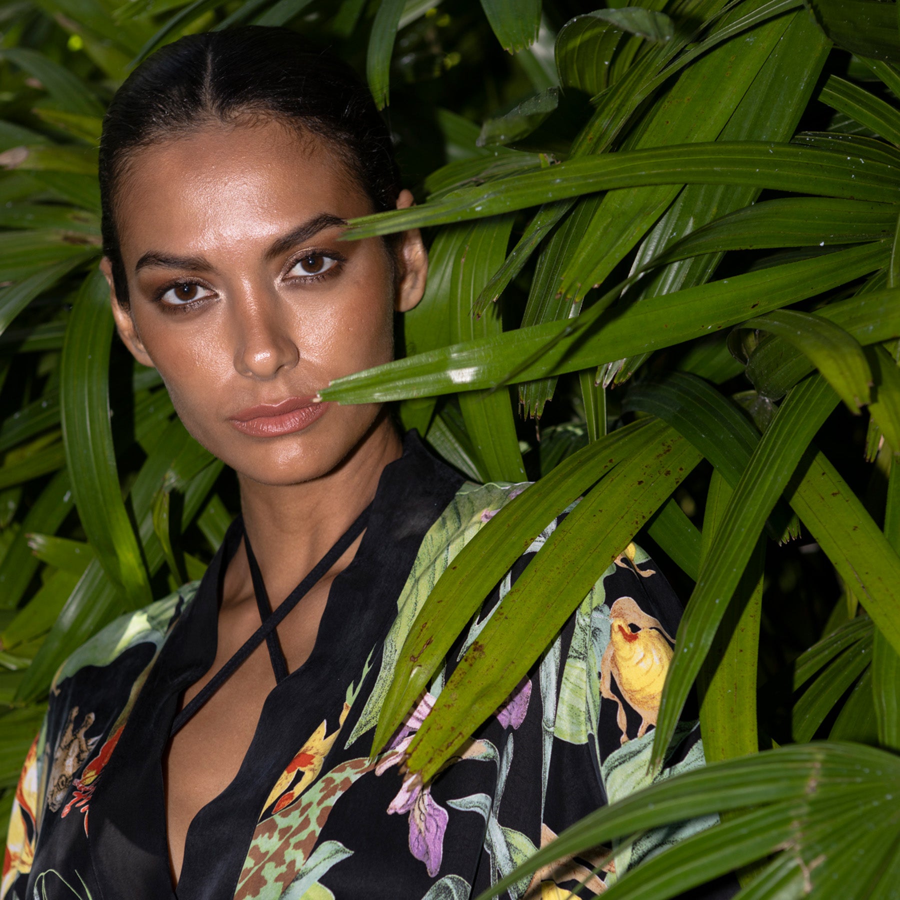 A person standing in front of a plant