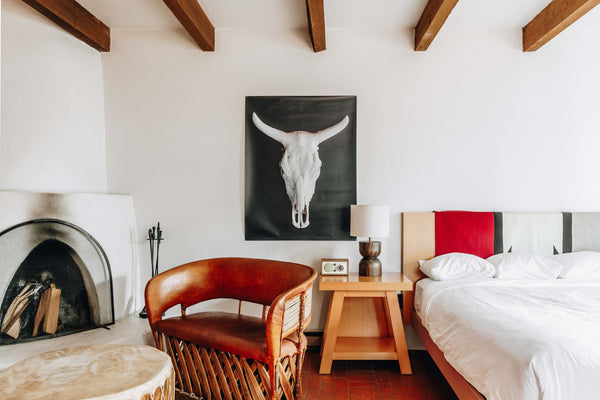 A room decorated with a tapestry, fireplace, and Tivoli Audio Model One BT at El Rey Court in Santa Fe, New Mexico