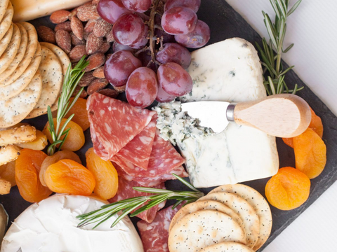A beautiful platter laid out with a selection of Milawa cheeses, crackers, dried apricots, salami and grapes.
