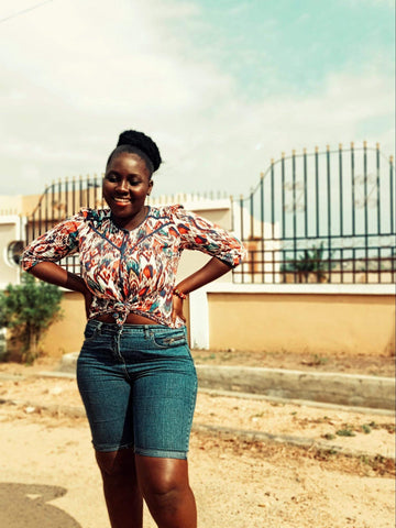 Alt-txt: woman standing outside wearing shorts and patterned shirt