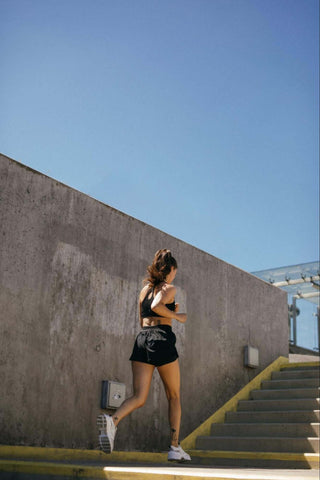 Alt-txt: woman running outside alongside a lake