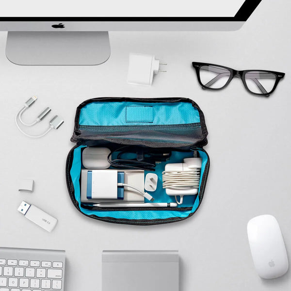 image of an imac some glasses cables and adpators being stored away in Zoomlite packing organiser cubes